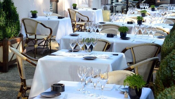 A restaurant with multiple tables set for dining, each with white tablecloths, chairs, and glassware. - LOGIS HOTEL LE PARC DE GEOFFROY (Thiers)