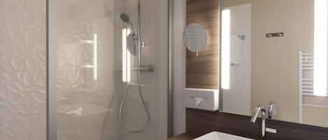 Un baño moderno con cabina de ducha de vidrio, tocador de madera y un espejo grande.