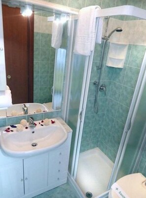 Ein Badezimmer mit Waschbecken, Spiegel und Dusche.
