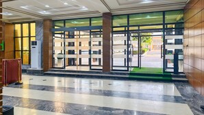 A hotel lobby with a marble floor, a reception desk, and a glass door entrance. - Jun Yue No. 9 Hotel  (Kano)