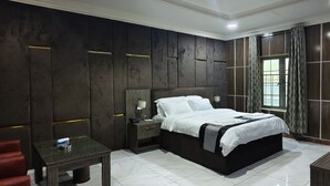 A modern hotel room with a large bed, a bedside table, a nightstand, and a window with curtains. - Jun Yue No. 9 Hotel  (Kano)