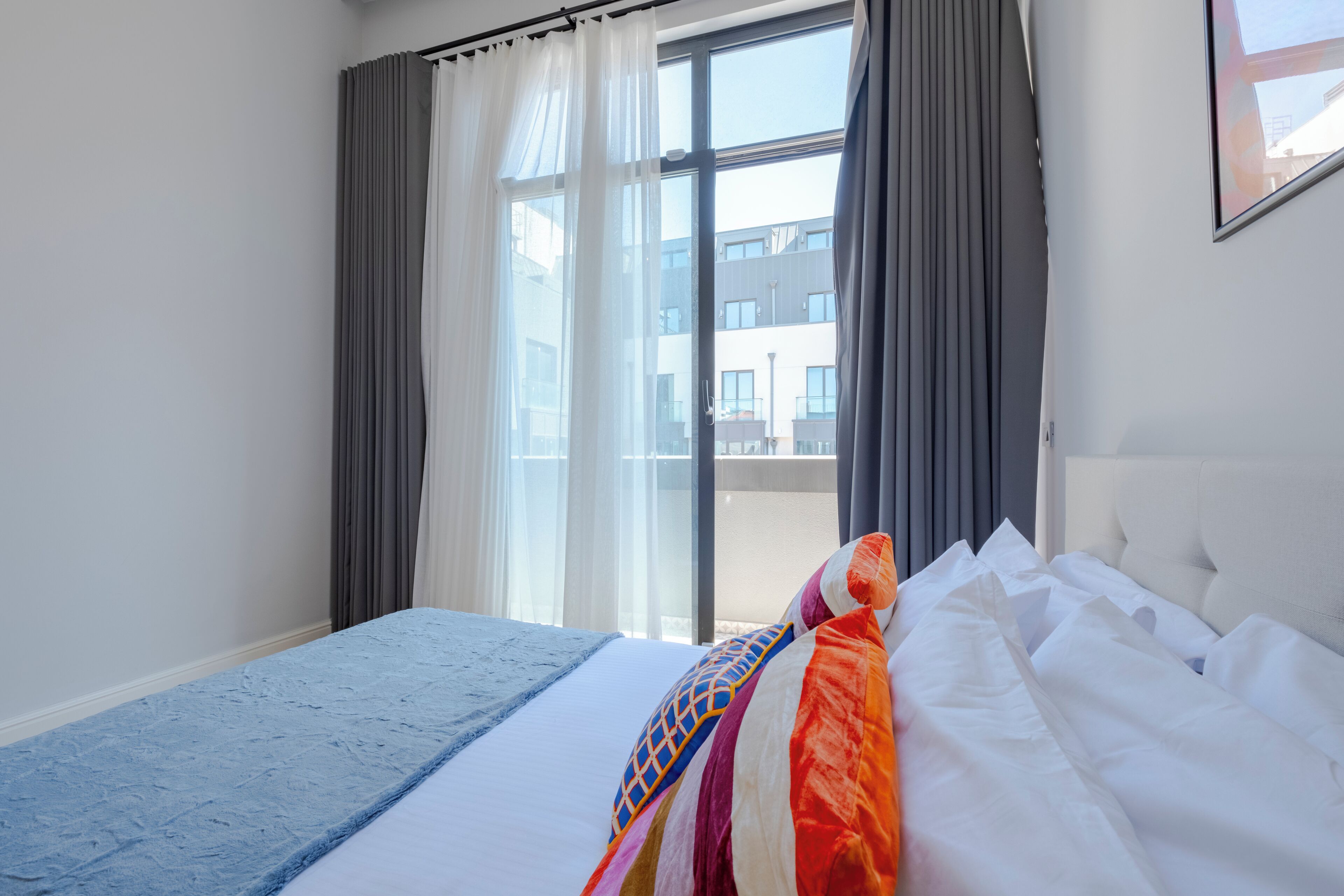 Une chambre d’hôtel avec un grand lit, une vue sur l’extérieur et une fenêtre avec des rideaux.