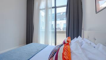 Une chambre d’hôtel avec un grand lit, une vue sur l’extérieur et une fenêtre avec des rideaux.