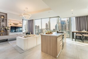 Uma sala de estar moderna com uma ilha grande, um sofá e uma televisão.