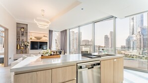 Una cocina moderna con una isla grande, electrodomésticos integrados y vistas a la ciudad a través de amplios ventanales.