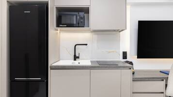 Estudio Deluxe, vista a la ciudad | Cocina privada | Refrigerador con congelador, microondas y parrilla de estufa