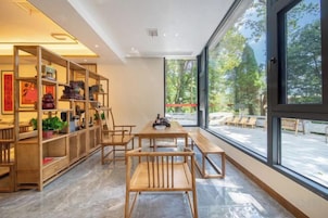 Un interior moderno con comedor, muebles de madera y ventanas amplias.