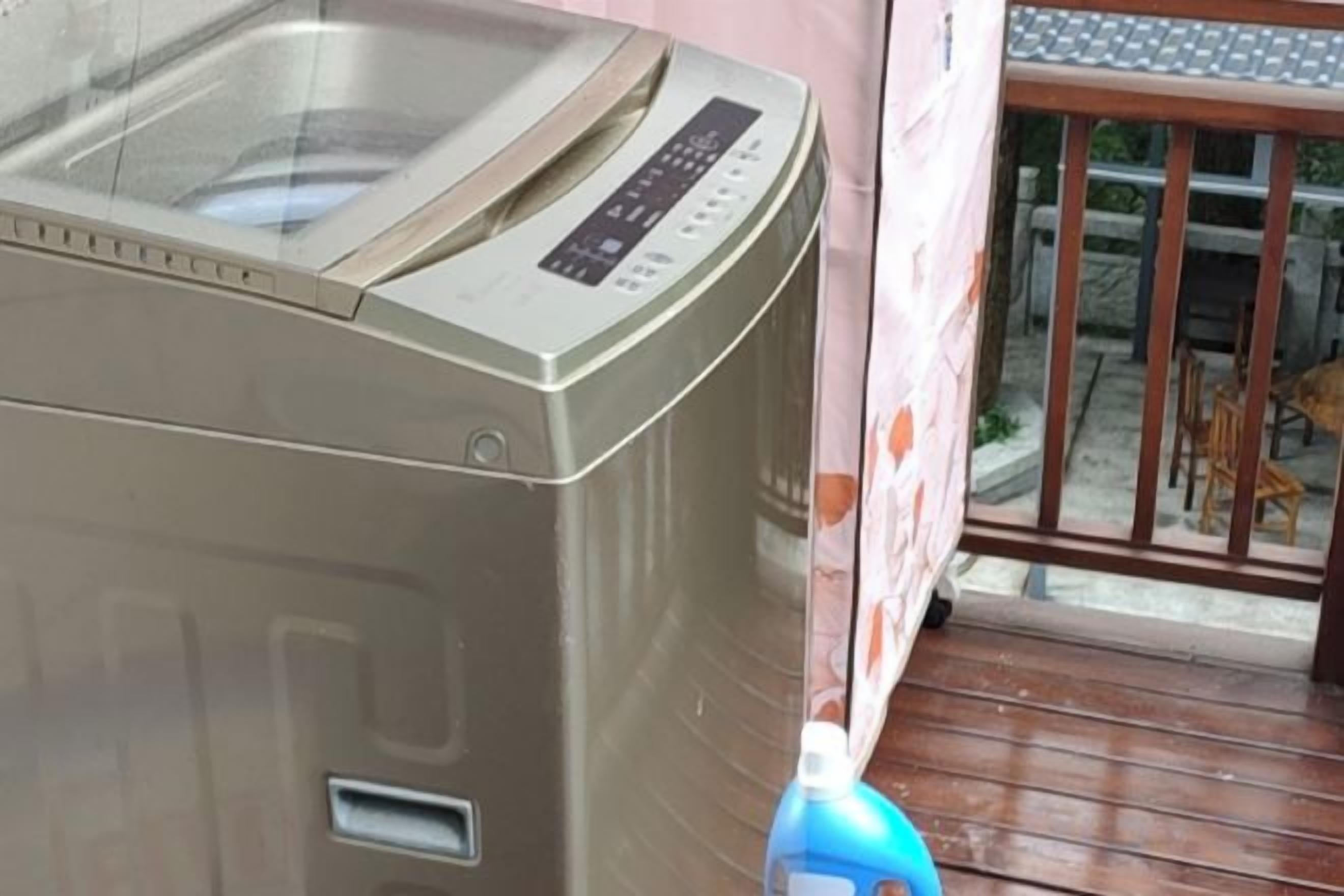 A washing machine with a control panel, located on a wooden deck.