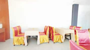 A room with a sofa set and a table, both covered with yellow and red fabric.