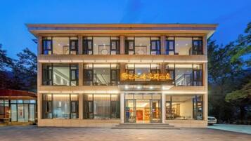 A two-story building with a glass facade, a visible entrance, and a sign above the doors.