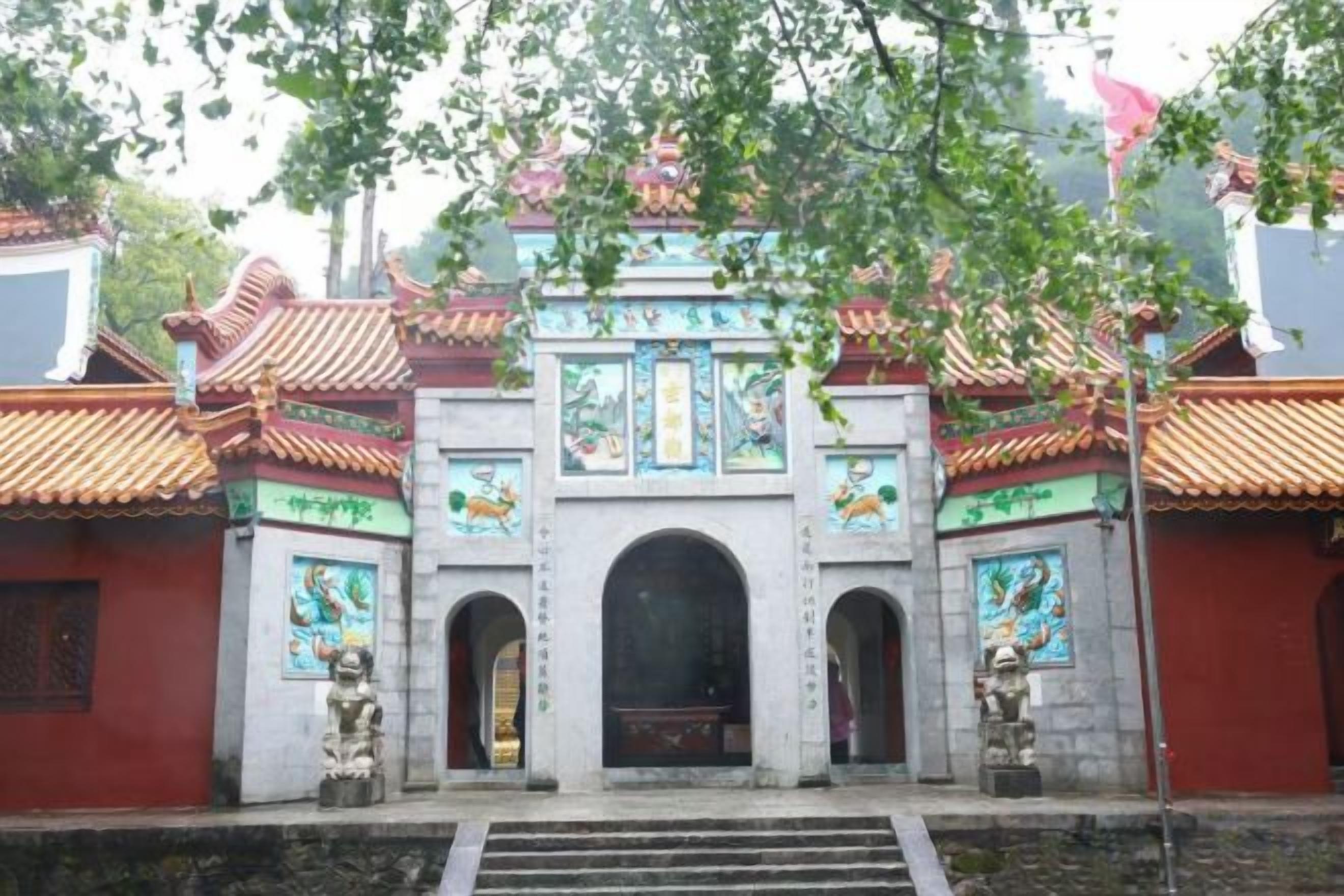 Une porte chinoise traditionnelle, ornée de motifs décoratifs, avec un escalier menant à son sommet.