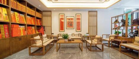 A lobby with a seating area, bookshelves, and framed artwork.