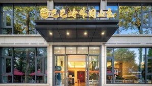 A modern building with large glass windows and a prominent entrance. - Babaling Leisure Hostel (Hengyang)