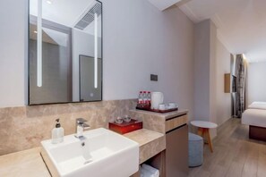 A modern bathroom with a large mirror, a sink, and a small table with toiletries. - Homeinn (Yangzhou)