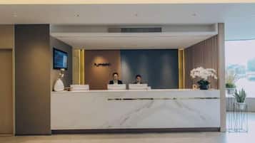 A reception desk with a marble top, two staff members behind it, and a 'Humann' sign on the wall.