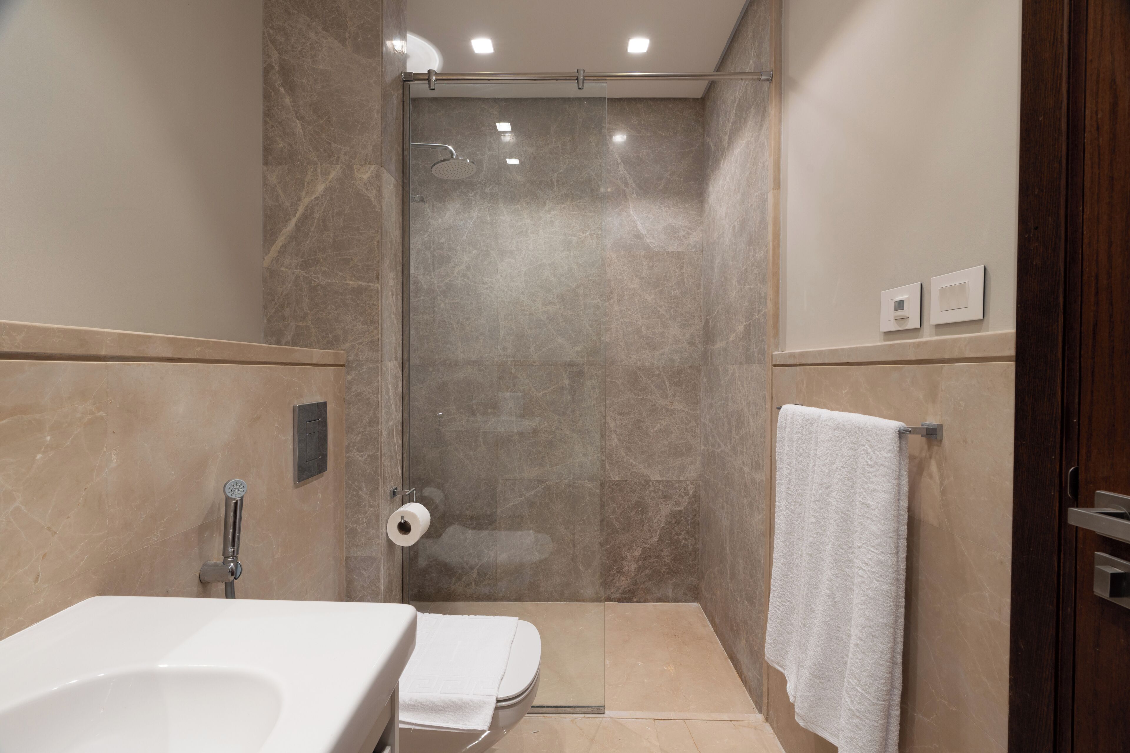 A bathroom with a shower, toilet, and sink.