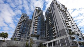A modern high-rise building with multiple balconies and a covered entrance area. - Brassbell l Sheikh Zayed l Aeon Towers  (6th of October City)