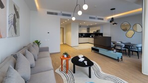 A modern living room with a sofa, coffee table, and dining area. - Brassbell l Sheikh Zayed l Aeon Towers  (6th of October City)