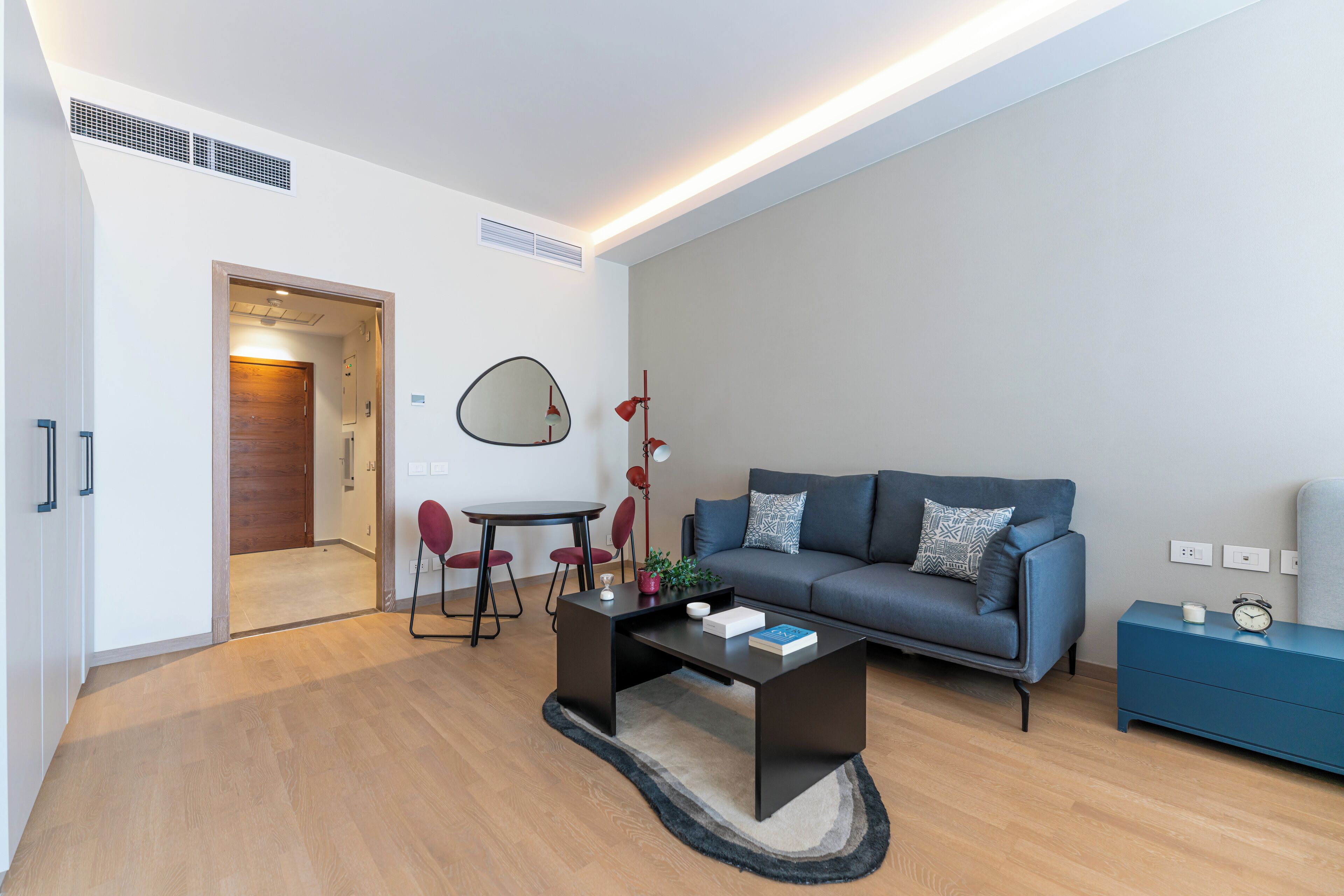 Un salon moderne comprenant un canapé, une table basse et un coin repas avec des chaises et une table.