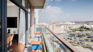 A balcony with a view of a parking lot and buildings. - Brassbell l Sheikh Zayed l Aeon Towers  (6th of October City)