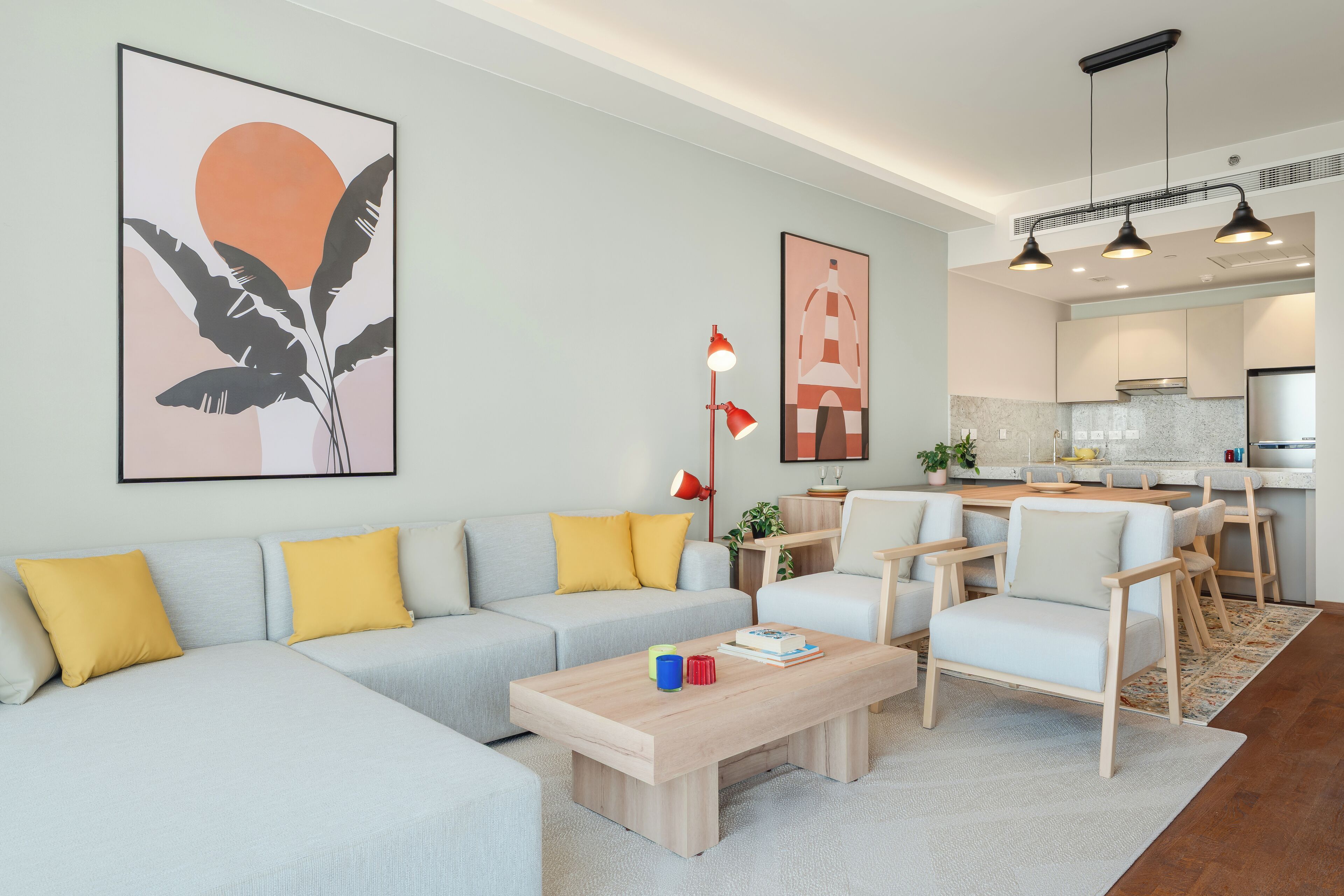 Un salon moderne avec un canapé, une table basse et des fauteuils. Il y a également un coin cuisine avec une table à manger et des chaises.