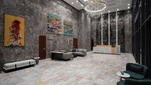 A spacious lobby with a marble floor, modern sofas, a reception desk, and artwork on the walls. - Brassbell l Sheikh Zayed l Aeon Towers  (6th of October City)