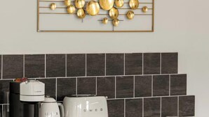 Una cocina de diseño moderno, con cafetera, hervidor y tostadora sobre la encimera.