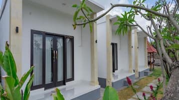 A modern two-story building with a white facade, dark-framed windows, and a small porch area.