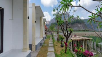 A pathway leading to a building with a view of a mountain range.