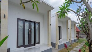 A modern building with white walls and dark-framed windows. - Batur Kencana Villa Mitra RedDoorz (Bali)