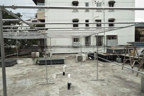 A rooftop with metal scaffolding, air conditioning units, and construction materials.