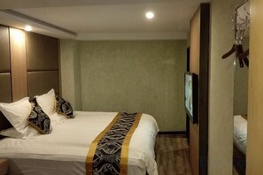 Una habitación de hotel con cama, televisión y armario.