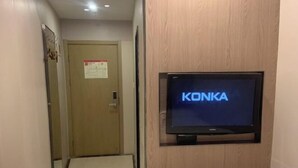 Un pasillo con una puerta identificada con 'KONKA' y una pantalla pequeña montada en la pared.