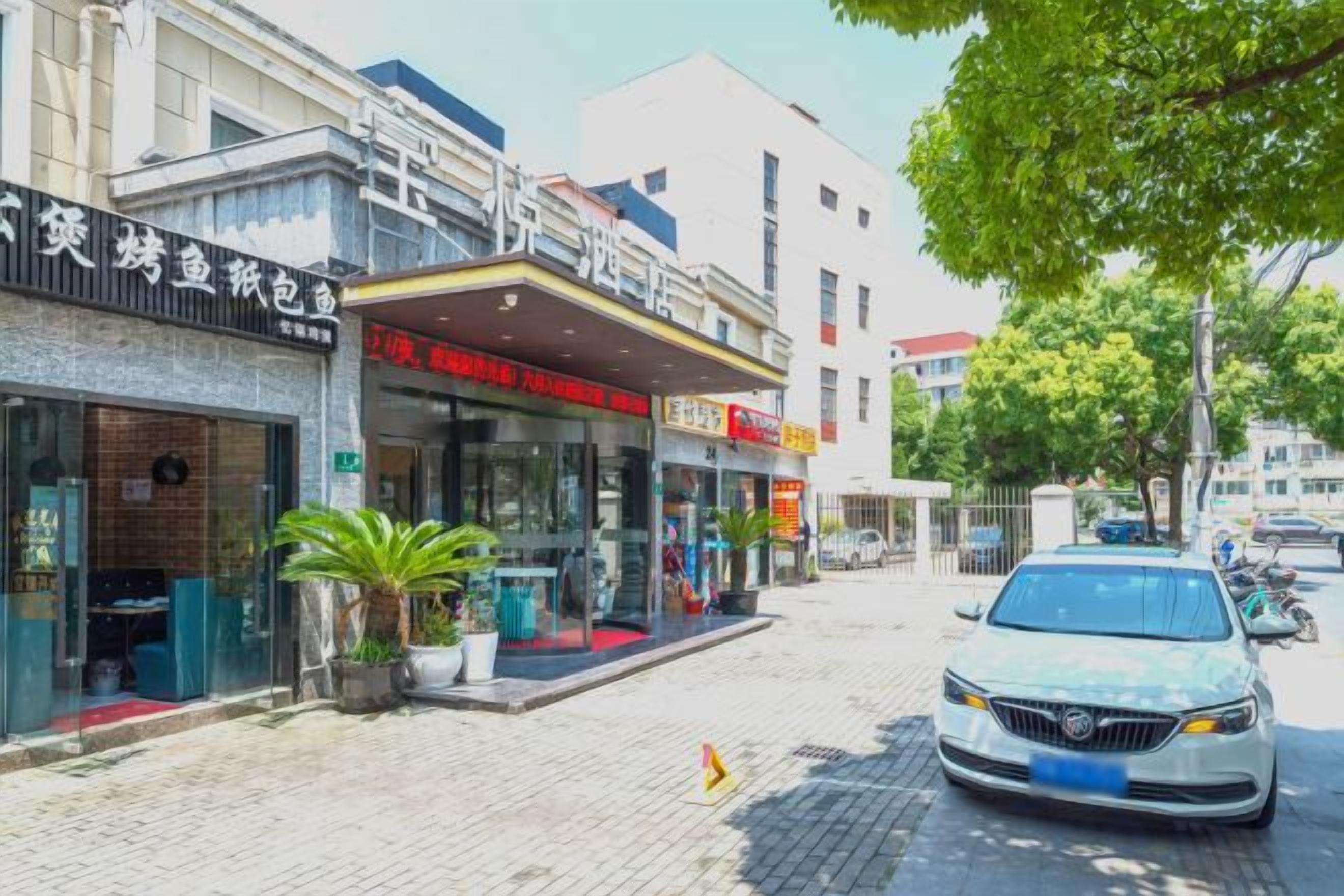 Vista de la calle con un restaurante y un coche estacionado.