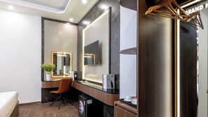 Una habitación de hotel moderna con un espejo grande, un escritorio y una silla.