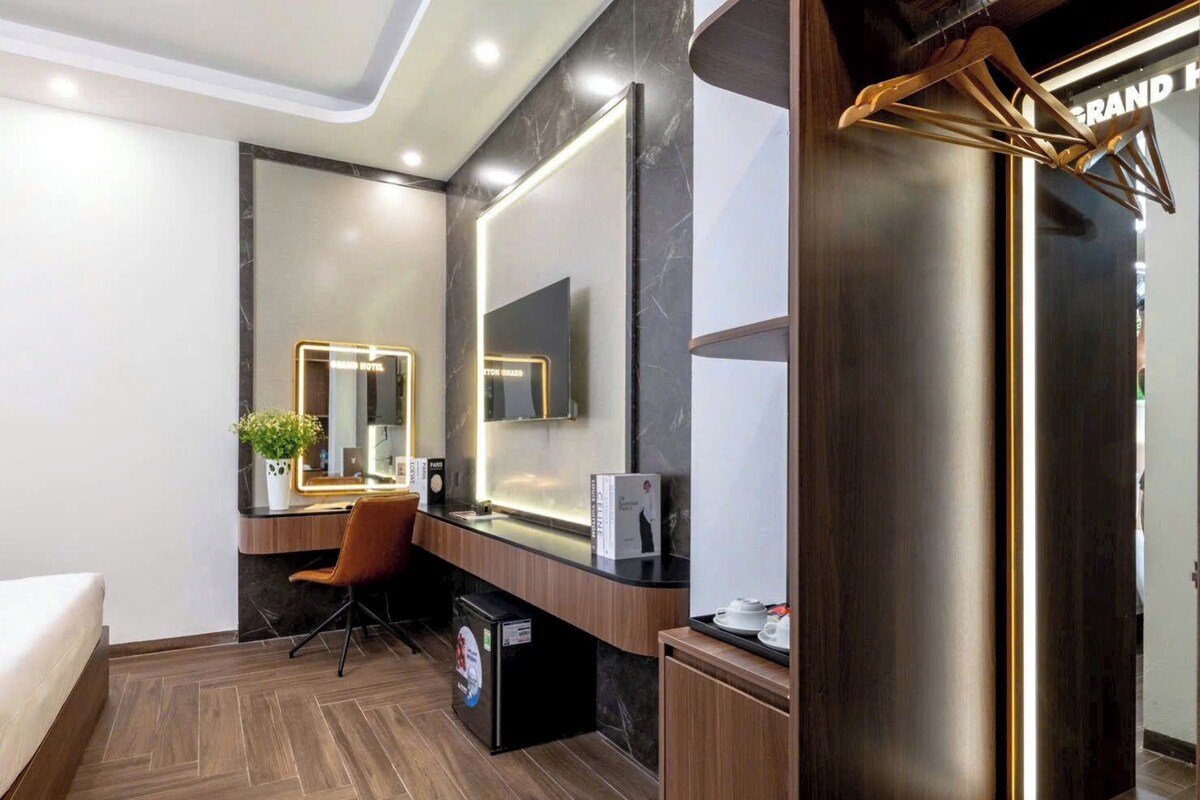 Una habitación de hotel moderna con un espejo grande, un escritorio y una silla.