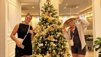 Imponente entrada de hotel con un árbol de Navidad y cajas de regalo.