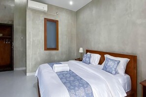 Un dormitorio con cama, mesita de noche, lámpara y armario.