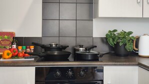 A modern kitchen with two stovetops, a range hood, and a built-in oven. -  Kozy Kottage, Near Hospital & Perfect for Families  (Hamilton)