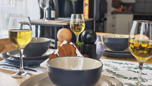 A dining table set with bowls, plates, and wine glasses. -  Kozy Kottage, Near Hospital & Perfect for Families  (Hamilton)