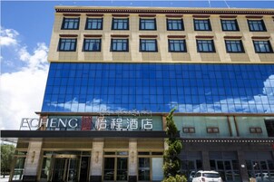 A hotel with a modern facade, large glass windows, and a sign in both English and Chinese.