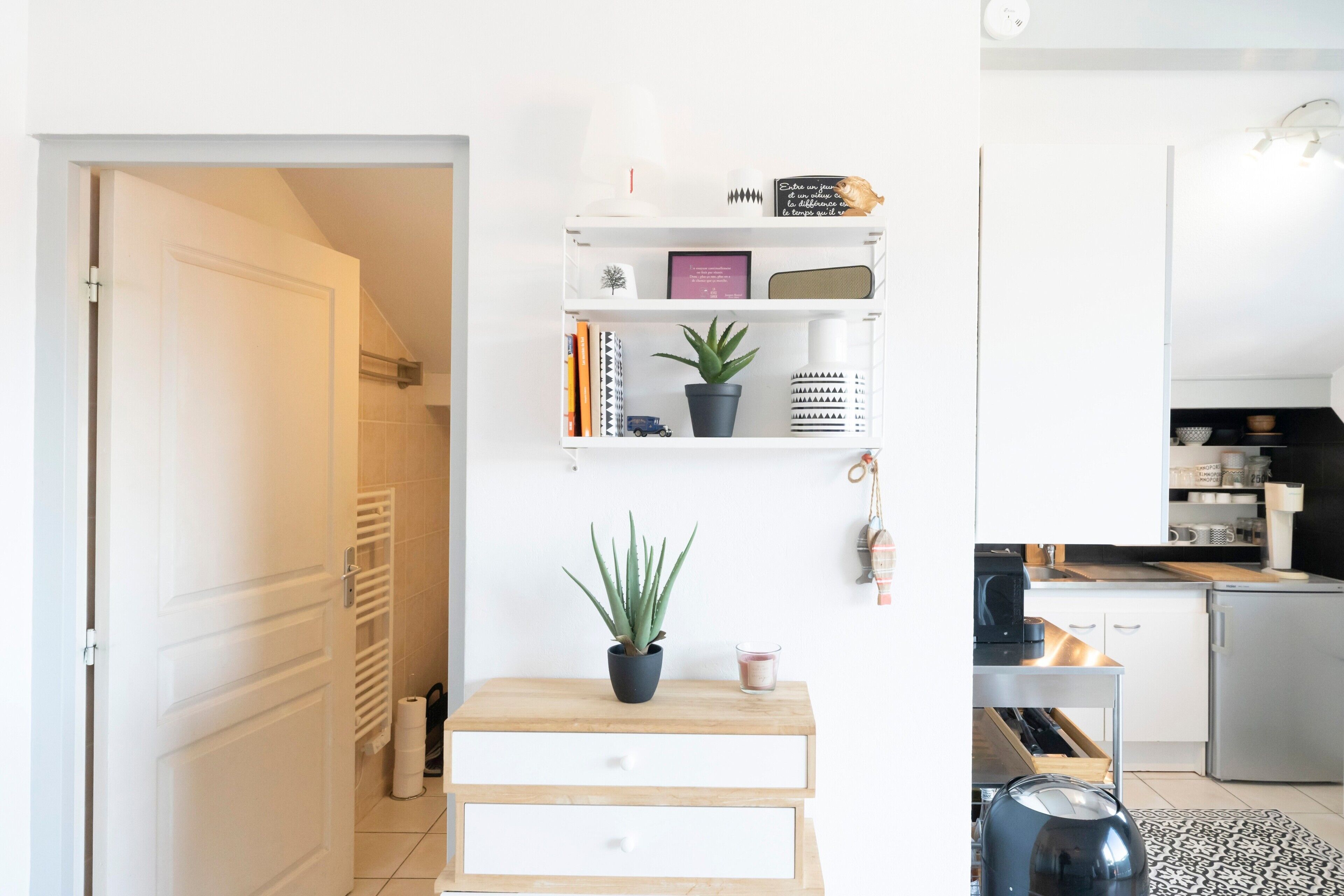 Una cocina moderna con armarios blancos, una encimera y una cafetera.