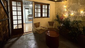 A cozy room with a rustic ceiling, a stone wall, and a seating area with chairs and a table. - Zébulon (Saint-Pierre)