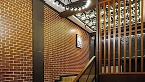 A staircase with wooden steps and a black handrail, leading to a wooden railing with vertical slats. - The Vega Resort  (Bang Lamung)