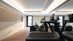 Et moderne fitnesscenter med løbebånd, crosstrainere og træningsudstyr.