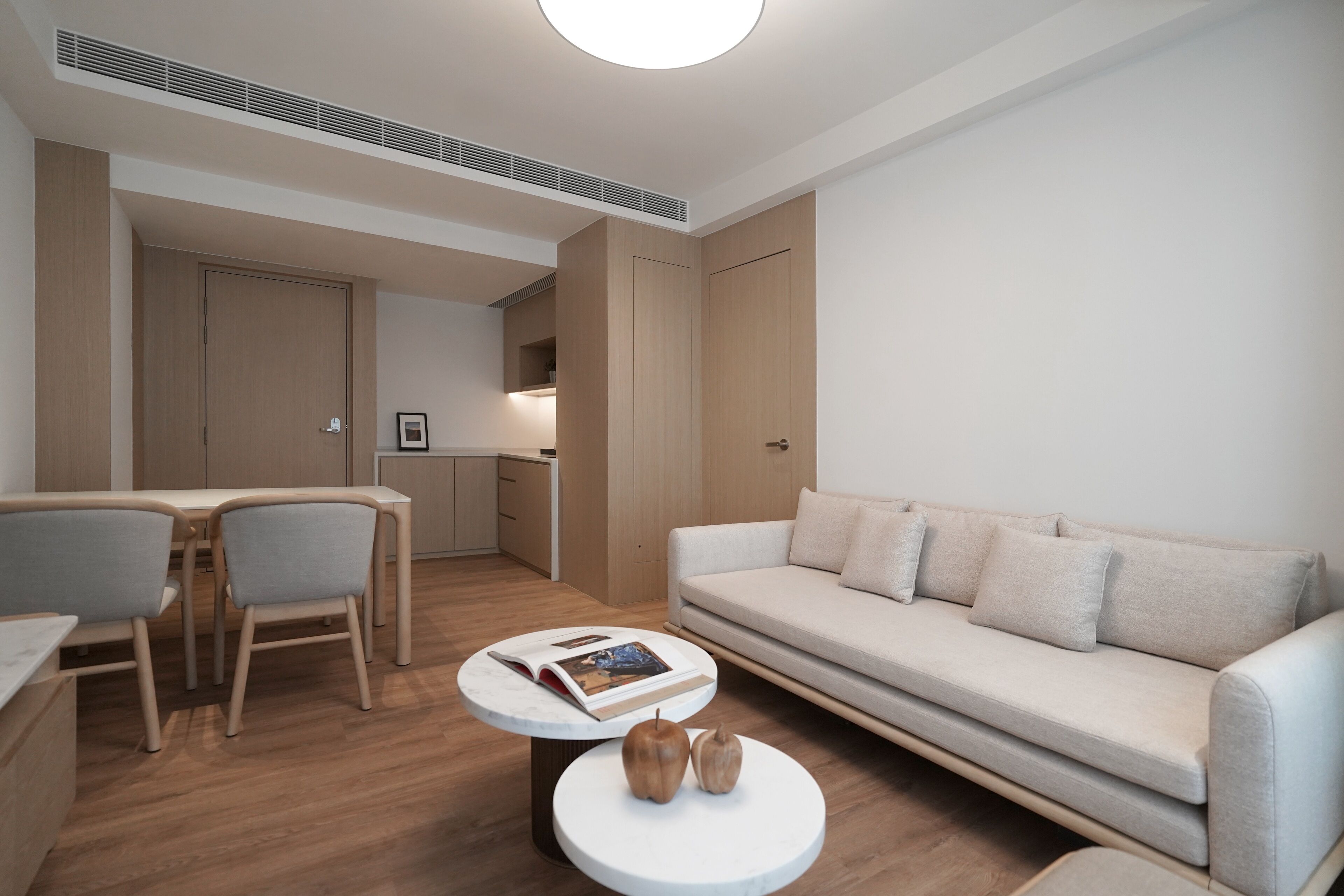 Een moderne woonkamer met een bank, stoelen, een eettafel en een bijzettafeltje.