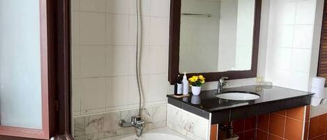 Uma casa de banho com banheira, lavatório e chuveiro.