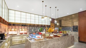 A modern buffet setup with a marble counter, various food items, and a brick wall backdrop. - yangjiangshibailiyichengjiudian  (Yangjiang)