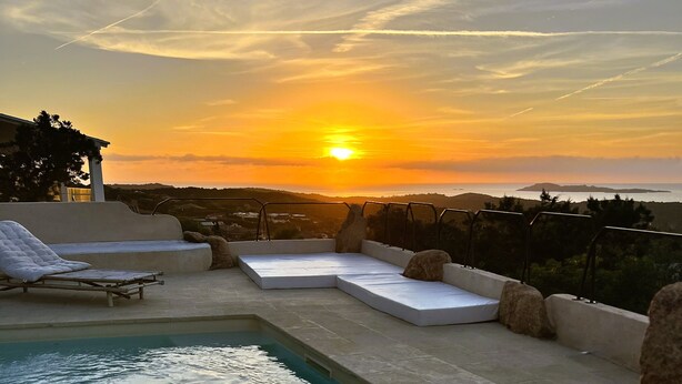A pool area with a sunset view, including a sun lounger and seating area. - DomoMea Porto Cervo (Arzachena)