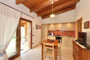 Deluxe Apartment | Living area | 24-inch flat-screen TV with satellite channels - Village with swimming pool just a few minutes from Alghero (Alghero)